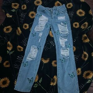 A pair f ripped jeans a, with a butterfly design, never worn before, great shape